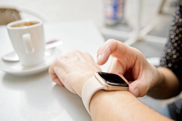 istock Woman looking at her smart watch during a coffee break 1189510514