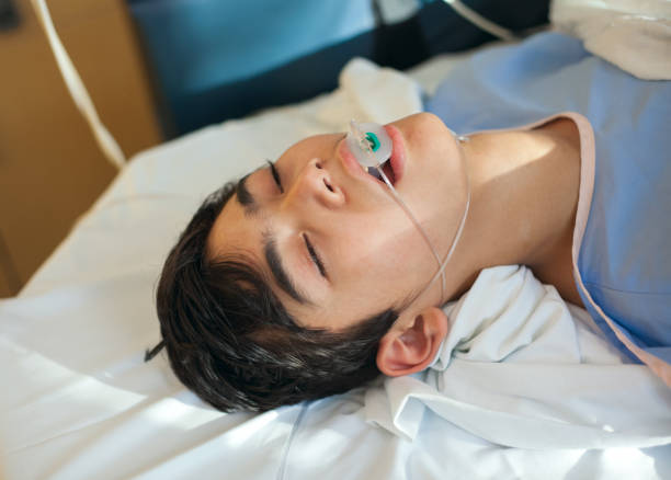 menino adolescente novo inconsciente no quarto de recuperação do hospital na maca - tranquilizing - fotografias e filmes do acervo