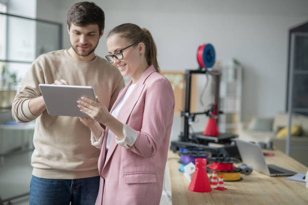 istock Happy businesswoman holding touchpad while her colleague making presentation 1189516573
