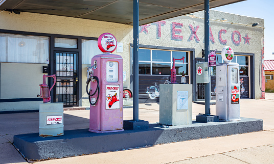 New Mexico, USA. May 14, 2019. Old-fashioned fuel pumps at gas station next to historic route 66. Building with logo background.