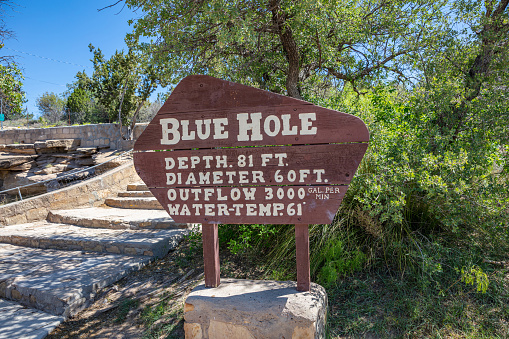 Santa Rosa, New Mexico, USA. May 14, 2019. The wooden sign on the rock inform about the Blue Hole, the famous deep pool, for the depth and the water temperature.