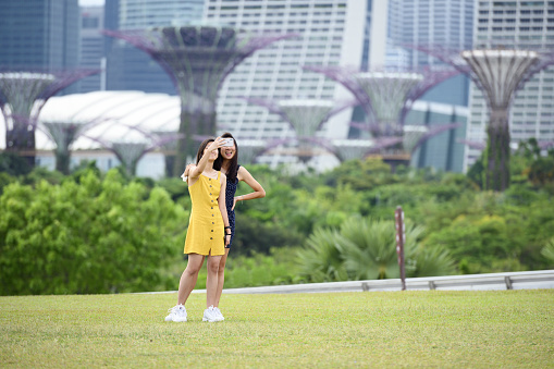 Singapore, November 23, 2019. Two beautiful girls are taking selfies in front of the skyline of Singapore. Singapore is a sovereign island city-state in Southeast Asia.
