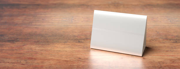 istock Table tent, reserved card sign empty blank on a wooden table, 3d illustration 1189518899