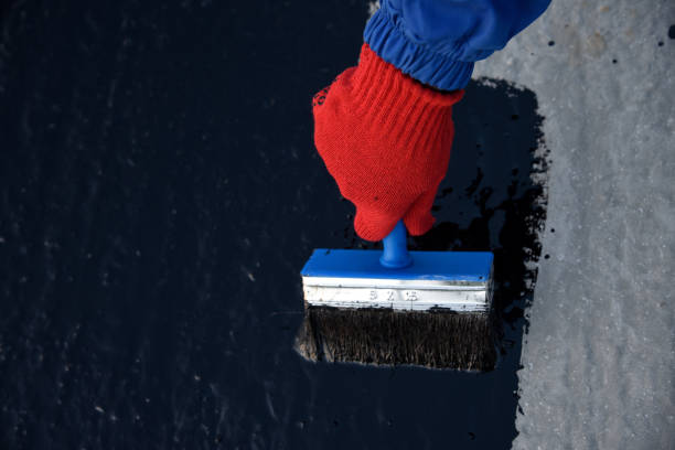 istock Worker applies bitumen mastic on the foundation 1189521944