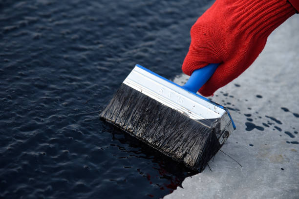 istock Worker applies bitumen mastic on the foundation 1189522565