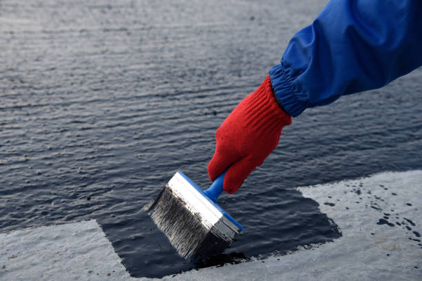 istock Worker applies bitumen mastic on the foundation 1189522602