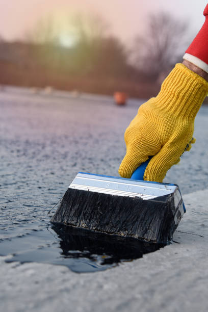 istock Worker applies bitumen mastic on the foundation 1189522603
