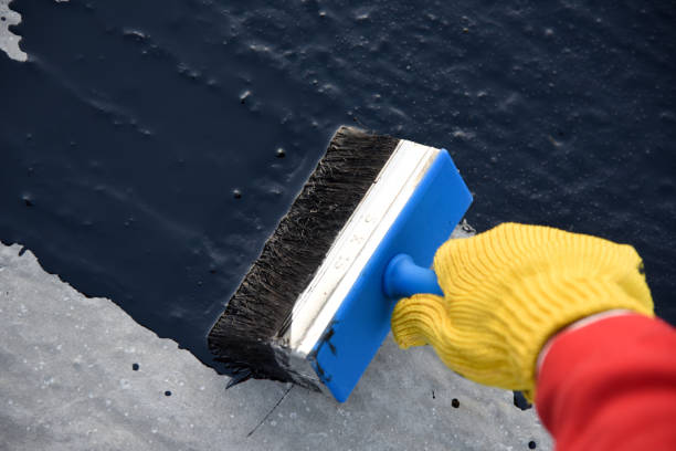 istock Worker applies bitumen mastic on the foundation 1189522627