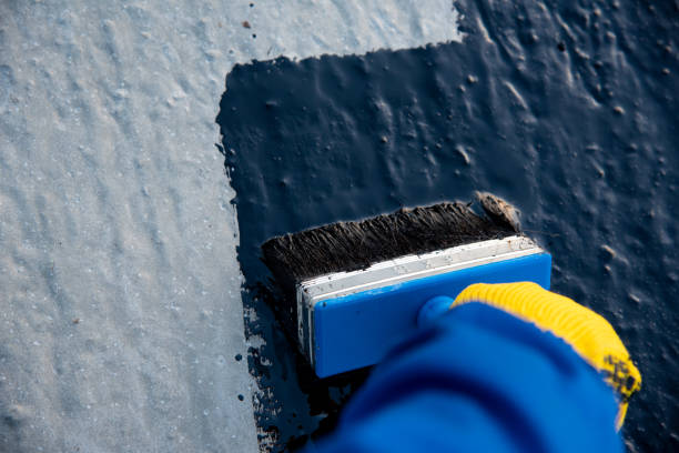 istock Worker applies bitumen mastic on the foundation 1189522652