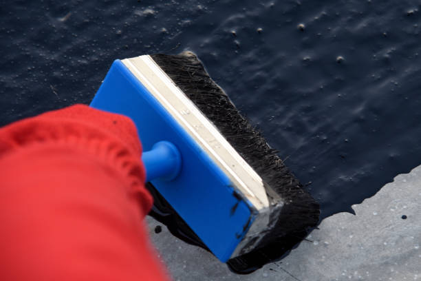 istock Worker applies bitumen mastic on the foundation 1189522677