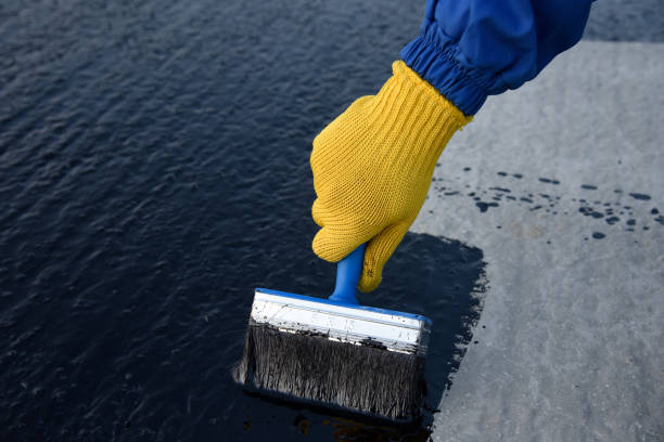 istock Worker applies bitumen mastic on the foundation 1189522816