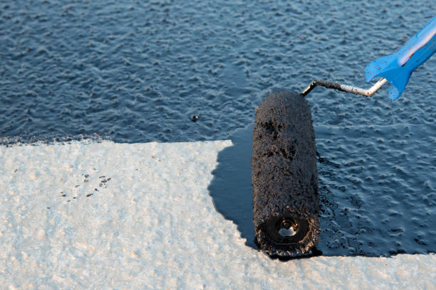 istock Worker applies bitumen mastic on the foundation 1189522855