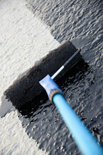 istock Worker applies bitumen mastic on the foundation 1189522872
