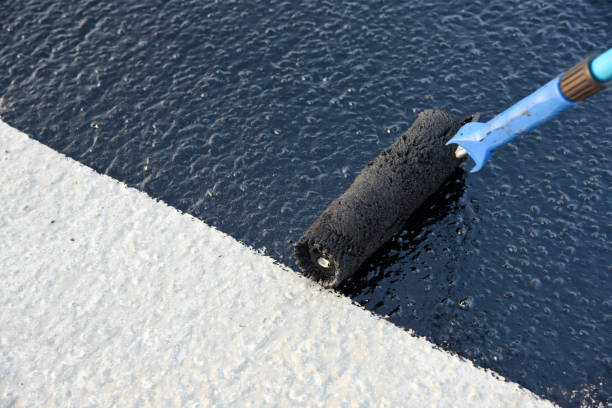 istock Worker applies bitumen mastic on the foundation 1189522928