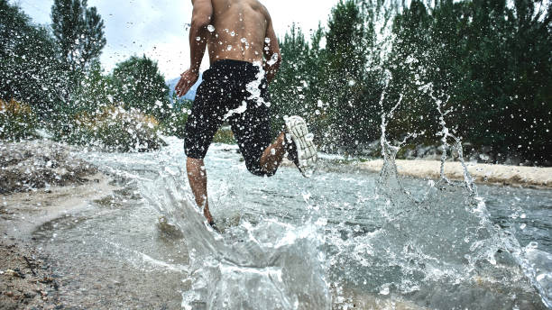 atleta asiático em um funcionamento da manhã no rio, corredor cazaque na natureza close-up - pumped - fotografias e filmes do acervo