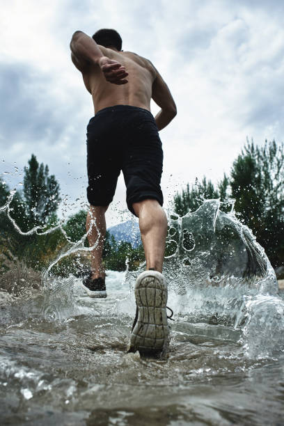 Asian athlete on a morning run on the river, Kazakh jogger in nature close-up Asian athlete on a morning run on the river, Kazakh jogger in nature close-up water athlete competitive sport vertical stock pictures, royalty-free photos & images