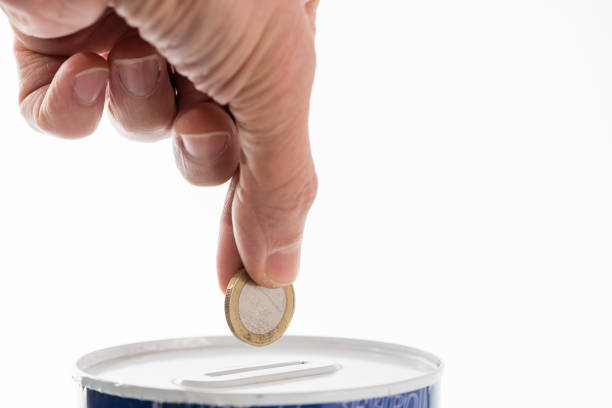 istock Male hand putting a coin into tin can saving bank 1189525646