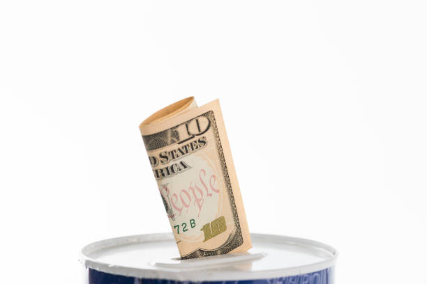 Close-up of can with bill in ten US dollar sticking out of it. White background.