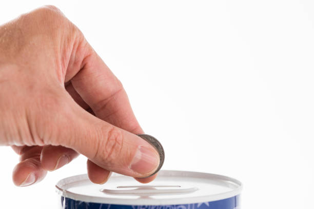 istock Male hand putting a coin into tin can saving bank 1189526214