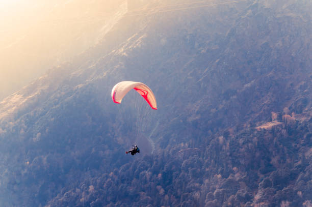 primo piano di un parapendio paracadutista colorato volante su uno splendido sfondo montano. solang nullah, distretto di kullu, area collinare di manali tehsil, himachal pradesh, asia meridionale, india - skydiving parachuting extreme sports airplane foto e immagini stock