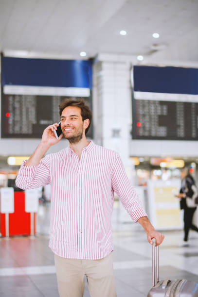 istock Handsome man making phone call in airport 1189530167