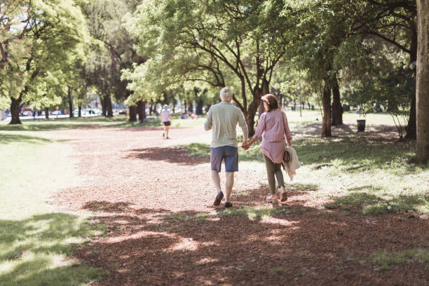 istock Senior couple walking in a park 1189531393