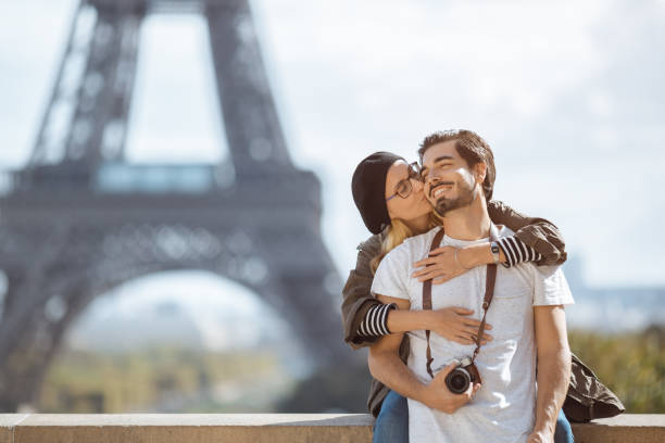 paris eiffelturm romantisches paar umarmt küssen vor dem eiffelturm, paris, frankreich - paris france eiffel tower love kissing stock-fotos und bilder