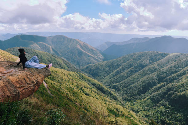 istock Single woman traveller looking at valley views while Sitting on the cliff 1189532631