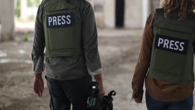 Reporters walking in war zone