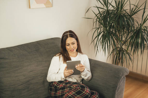istock Young woman using her tablet at home coach 1189533614