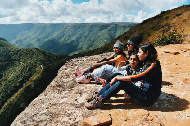 istock Family members looking at valley views while sitting on the cliff 1189533625
