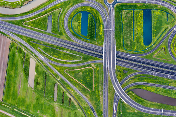 A cloverleaf highway with traffic in the middle of green fields A cloverleaf highway with traffic in the middle of green fields berkel stock pictures, royalty-free photos & images