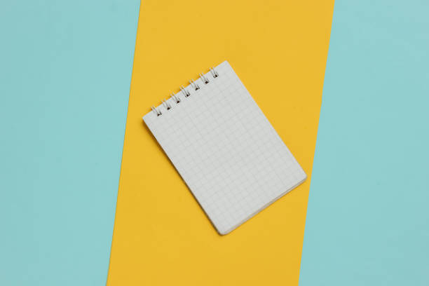 istock Notebook close-up on blue yellow background. Top view 1189535716