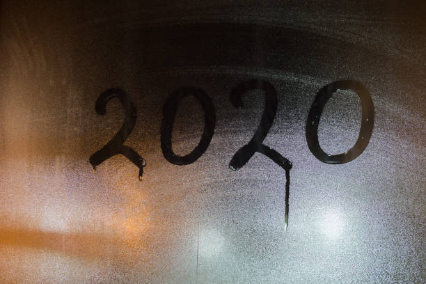 istock digit 2020 written on night wet window glass close-up 1189536665