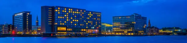 Panoramic view at night across the office buildings, hotels, apartment buildings and bridges that line the harbour waterfront in central Copenhagen, Denmark’s vibrant capital city.