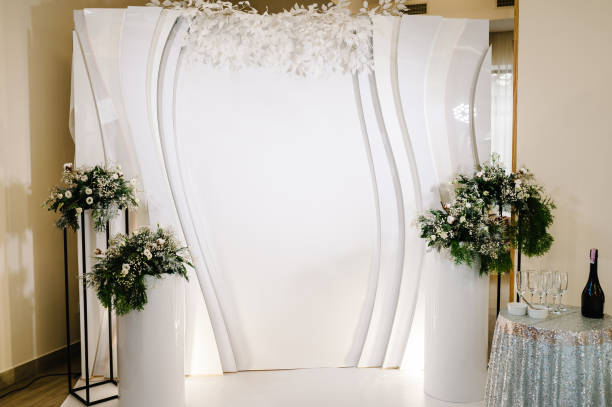 Decorated wedding arch in winter with fur tree branches. Christmas winter wedding. Event. Photo-wall, decoration space or place. Decorated wedding arch in winter with fur tree branches. Christmas winter wedding. Event. Photo-wall, decoration space or place. wedding hall stock pictures, royalty-free photos & images