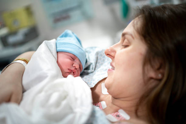 mère regardant son bébé pour la première fois - cesarean photos et images de collection