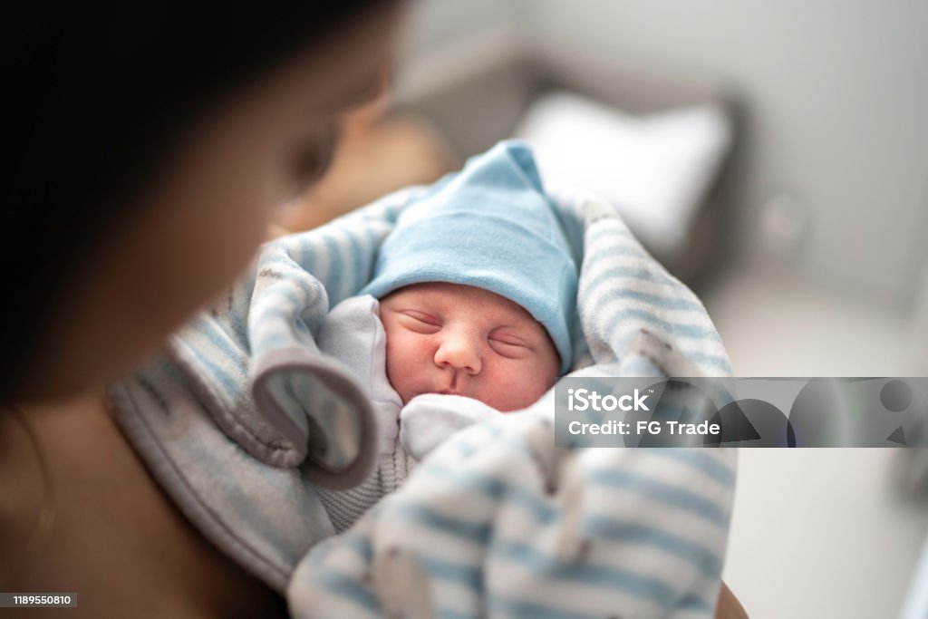 Women holding and looking at her godson at hospital Newborn Stock Photo