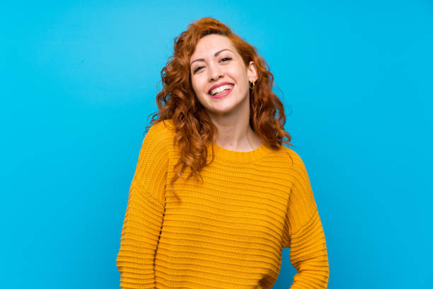 istock Redhead woman with yellow sweater smiling 1189551460