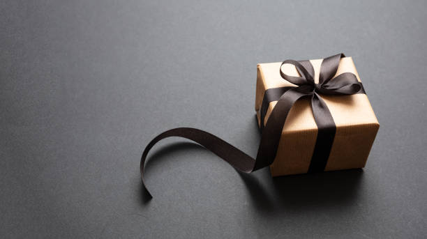 istock Gift box with black ribbon against black background, Black Friday concept. 1189551700