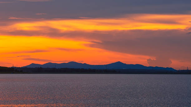 ciel de coucher du soleil et grand soleil au-dessus du lac. - dramatic sky dusk night sustainable resources photos et images de collection