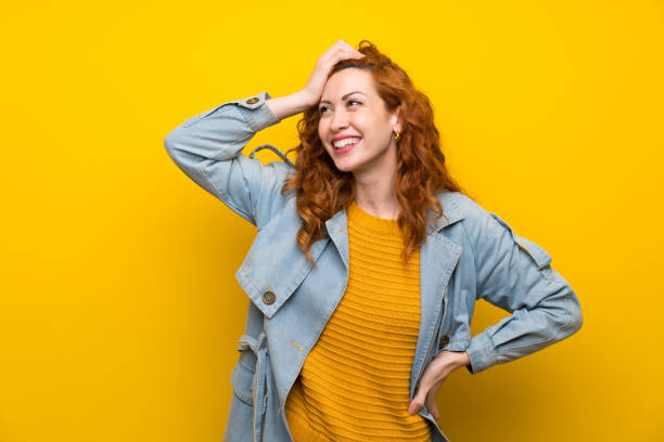 istock Redhead woman over isolated yellow background laughing 1189553217