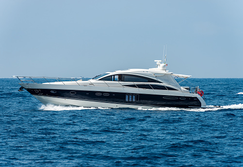 Tellaro, La Spezia, Liguria, Italy - July 21th, 2019: White and blue luxury yacht in motion on the Mediterranean sea, side view, Gulf of La Spezia, Liguria, Italy, Europe