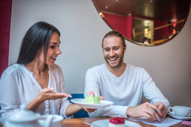 istock Bearded businessman smiling while trying desserts with wife 1189554927