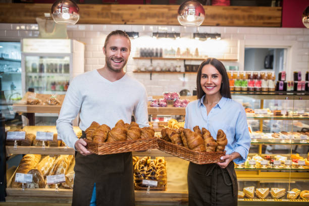 istock Couple holding boxes with croissants standing in their bakery 1189555061