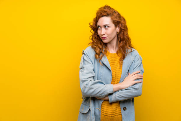 istock Redhead woman over isolated yellow background standing and thinking an idea 1189555227