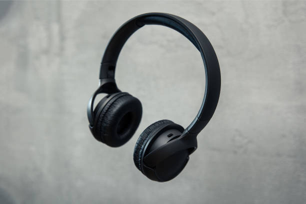 Headphones floates over concrete background Headphones floates over concrete background headphones plugged in photos stock pictures, royalty-free photos & images
