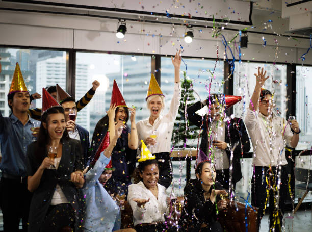 giovani imprenditori sorridenti alla festa di capodanno nel piccolo ufficio e bere champagne per la celebrazione di capodanno. - party business toast champagne foto e immagini stock