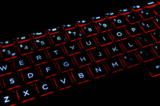 istock Close up view of a modern laptop computer keyboard keys. Soft lightning in red tones. Pc computer keyboard close up 1189559776