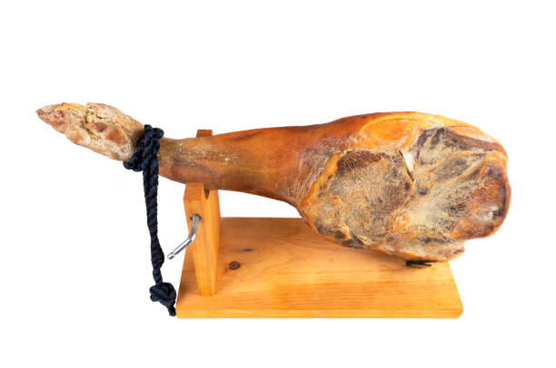 istock Jamon serrano. A Spanish ham isolated on white background. Traditional spanish jamon serrano leg isolated. Dry cured meat ham. Whole leg. Jamon on jamonero stand 1189559950